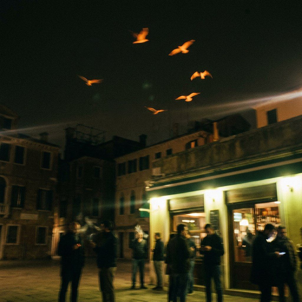 A cluster of orange-lit birds wheeling low over a corner shop at night, people queueing under the awning, one long light-streak crossing the sky.